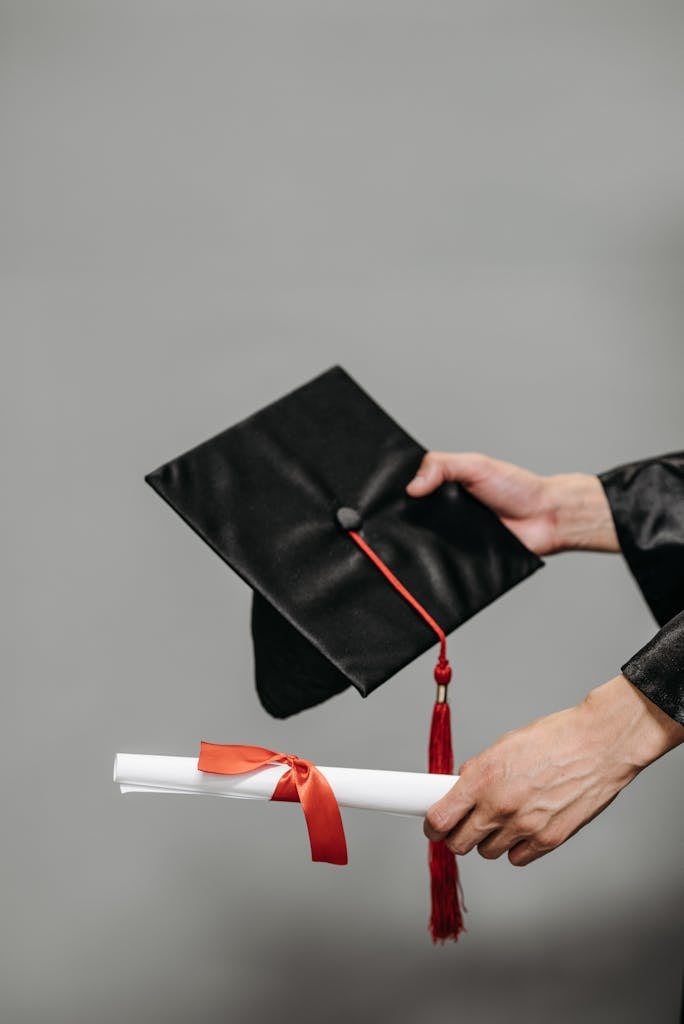 Photo of Person Holding Black Academic Hat